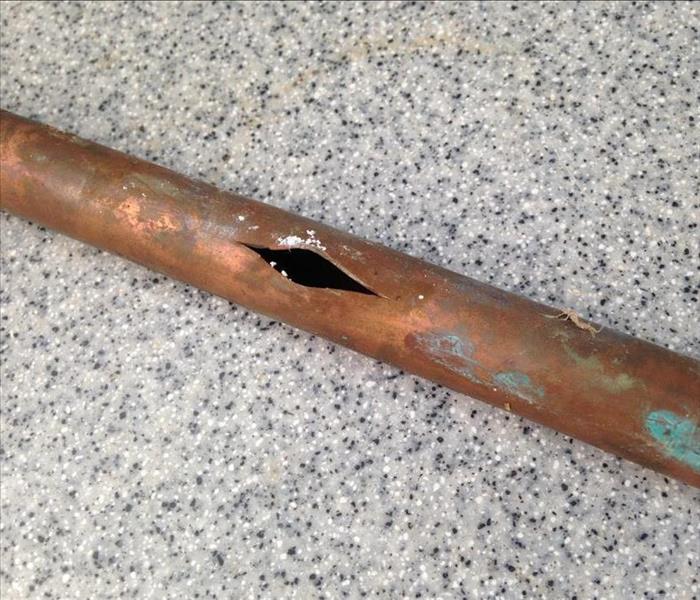 Old rusty pipe with small hole in the middle.  