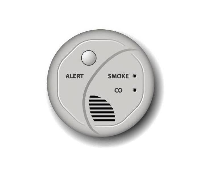 Small white smoke detector on ceiling of home
