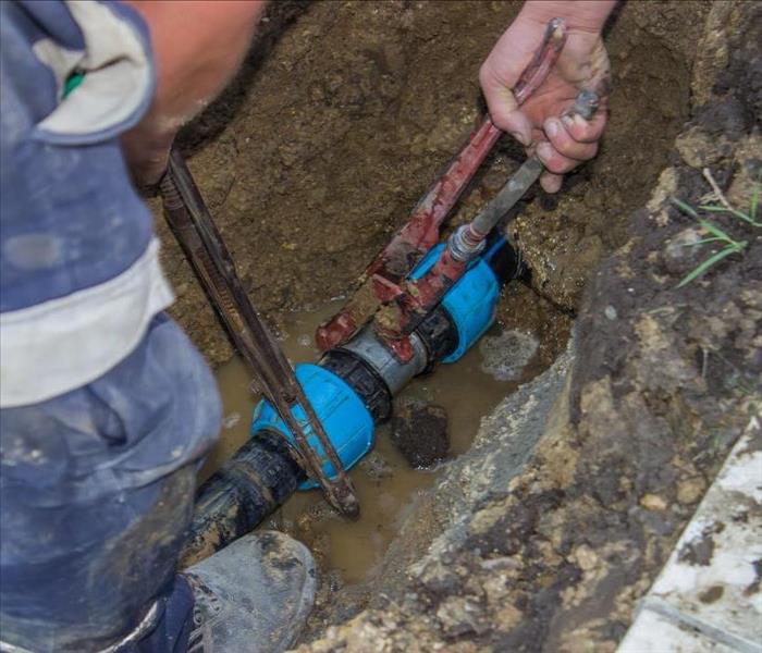 Image of 2 persons installing a pumping system