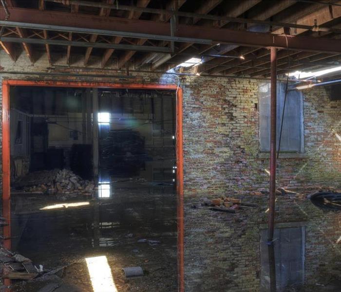 Image of a damaged building, walls and ceiling have been damaged and also flooded floor. 
