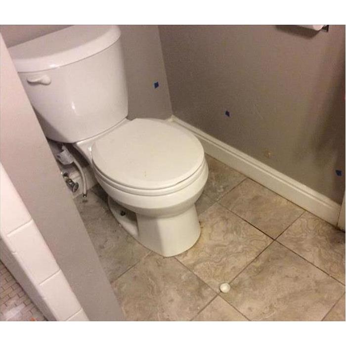 White toilet leaking water in bathroom